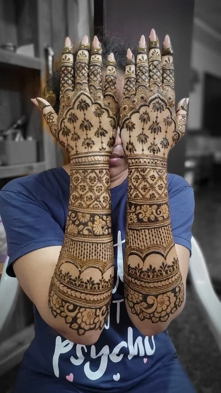 Bride holding up fresh bridal mehandi on both arms, mehandi for Giridih weddings