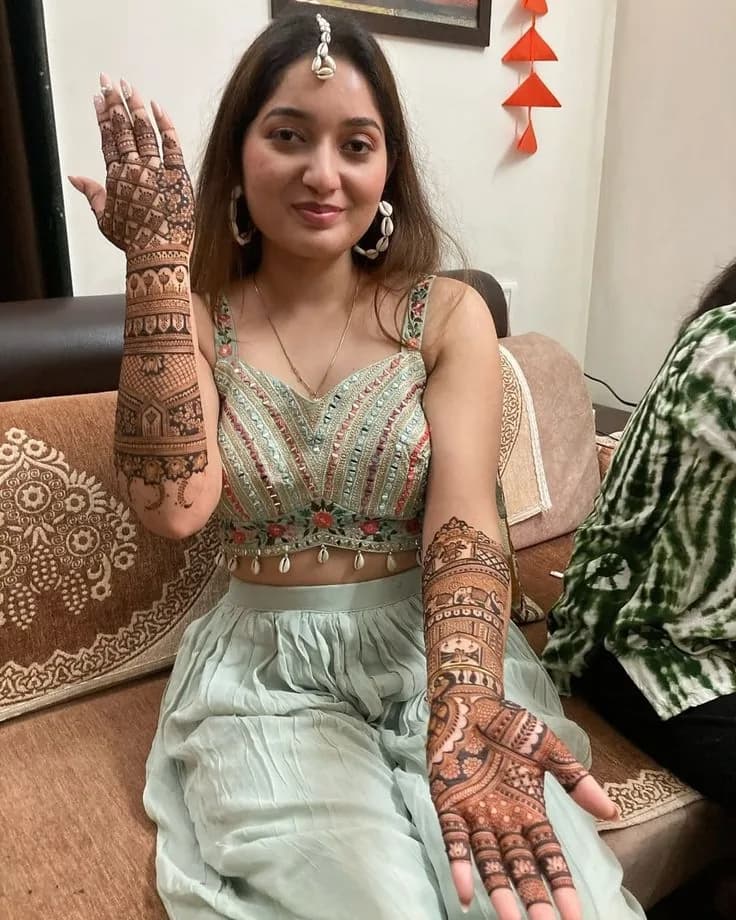 Client in a lehenga showing full arm mehandi